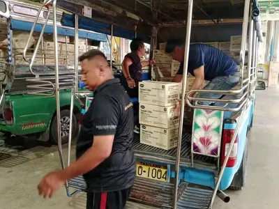 ขนลังขนมเทมเป้ทอดกรอบขึ้นรถเพื่อนำไปยังโรงเรียน