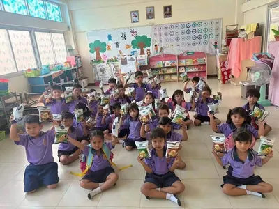 นักเรียนโรงเรียนประถมศึกษารับขนมเทมเป้ทอดกรอบที่วัดจุฬามณีมอบให้